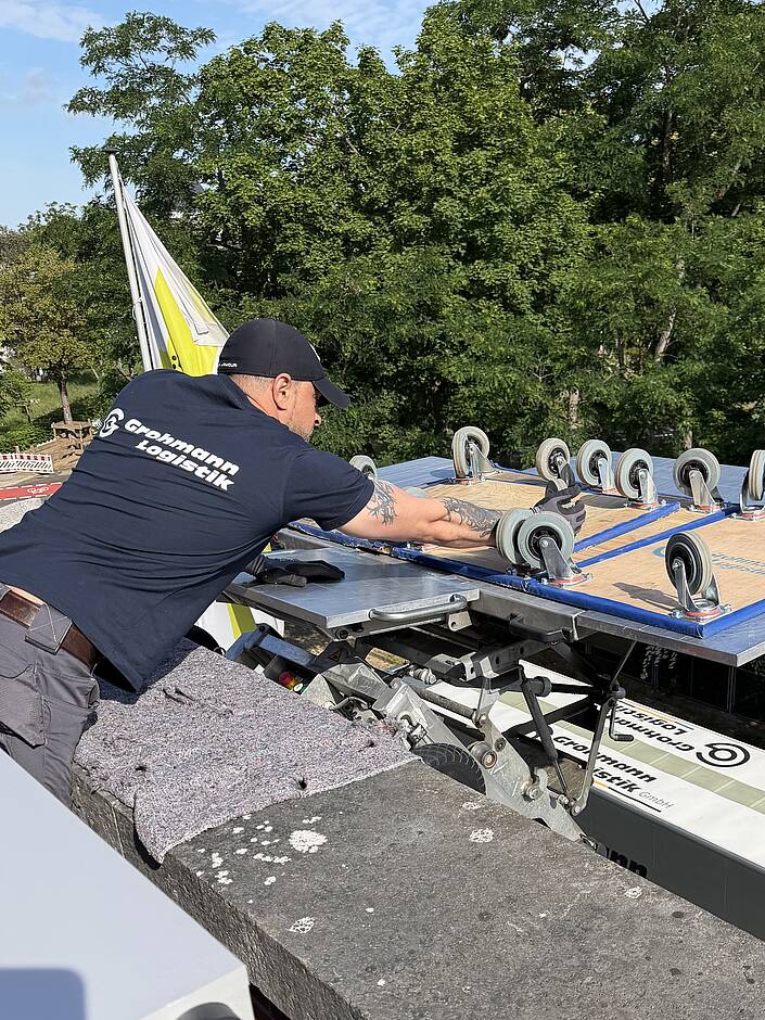 Umzugshelfer der sich über eine Balkonbrüstung lehnt
