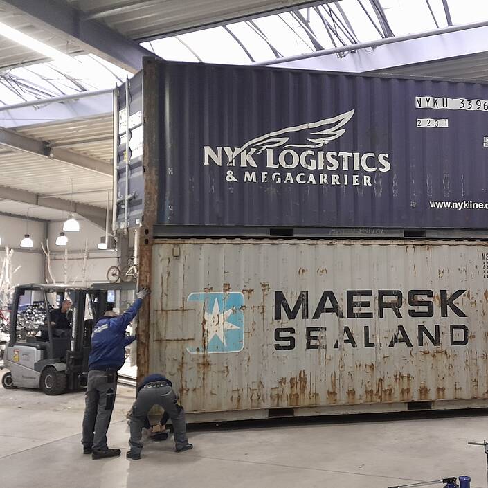 Mitarbeiter der Gohmann Logistik GmbH beim Aufeinandersetzen von Überseecontainern