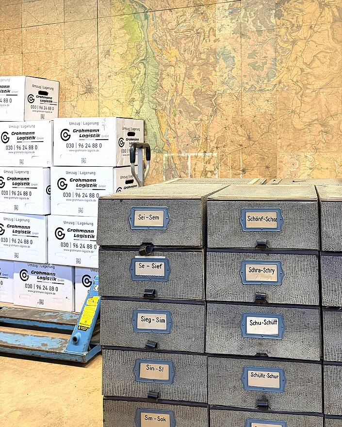 Umzugskartons, im Vordergrund Archivkästen