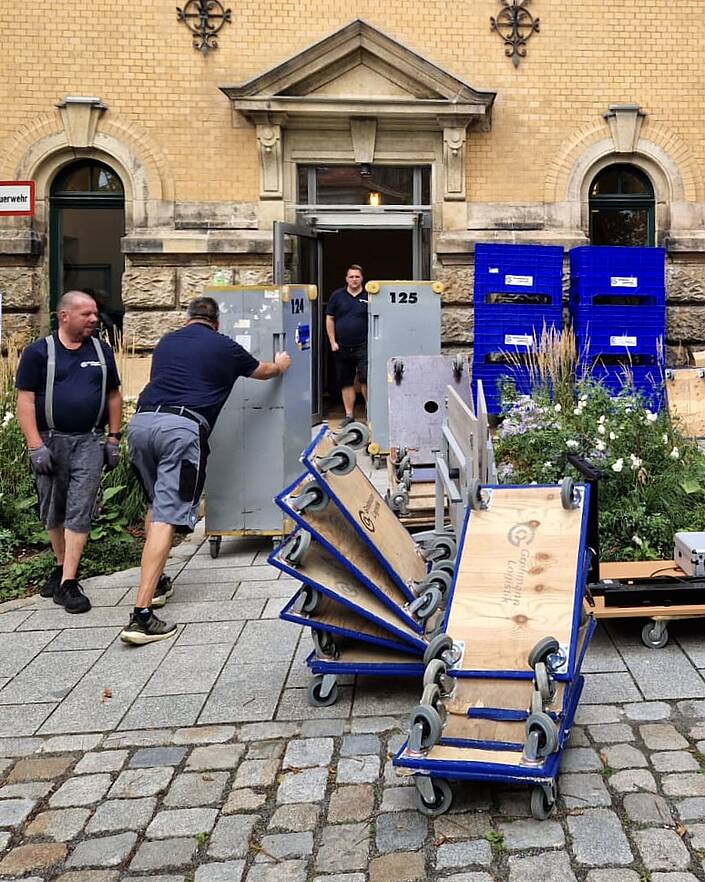 Mehrere Umzugshelfer vor einem Gebäude