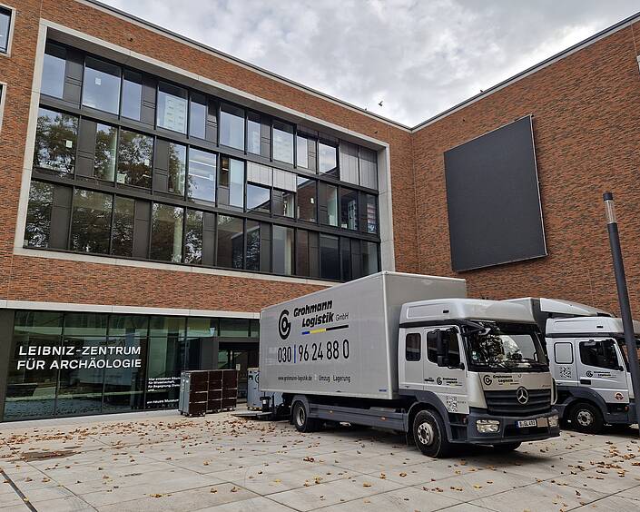 Ansicht des Leibniz-Forschungsinstitut für Archäologie. Im Vordergrund zwei LKWs der Grohmann Logistik GmbH