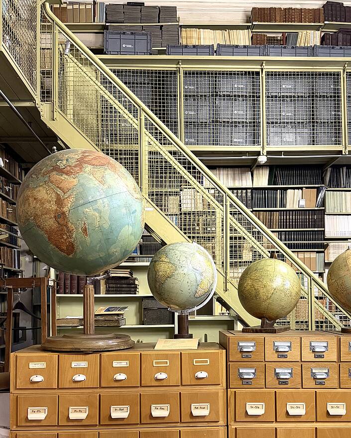 Globen vor Bücherregal