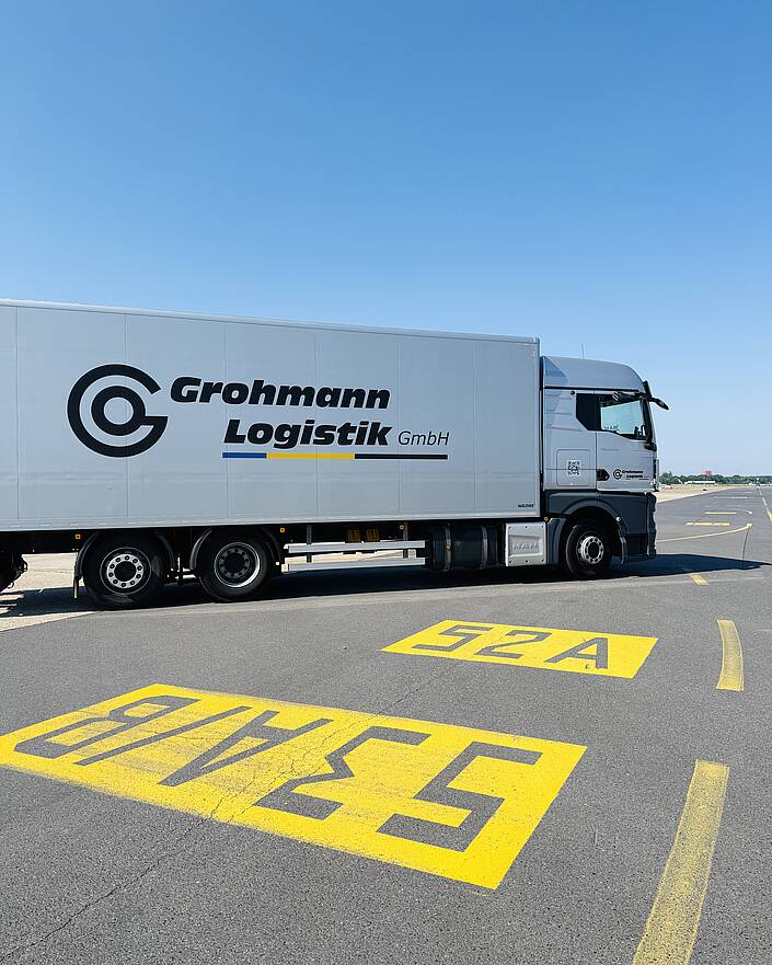 LKW mit Aufschrift Grohmann Logistik auf Start- und Landebahn eines Flughafens